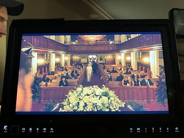 living-with-grandma-04 Video monitor on the Living With Grandma set, showing a scene filmed in a large reception hall.